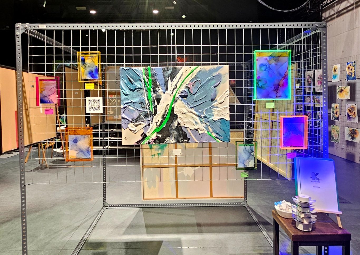 Alkohol Ink Bilder auf der MonArt30 Eine Kunstausstellung mit einem großen Gemälde und farbigen Bildern in Rahmen.
