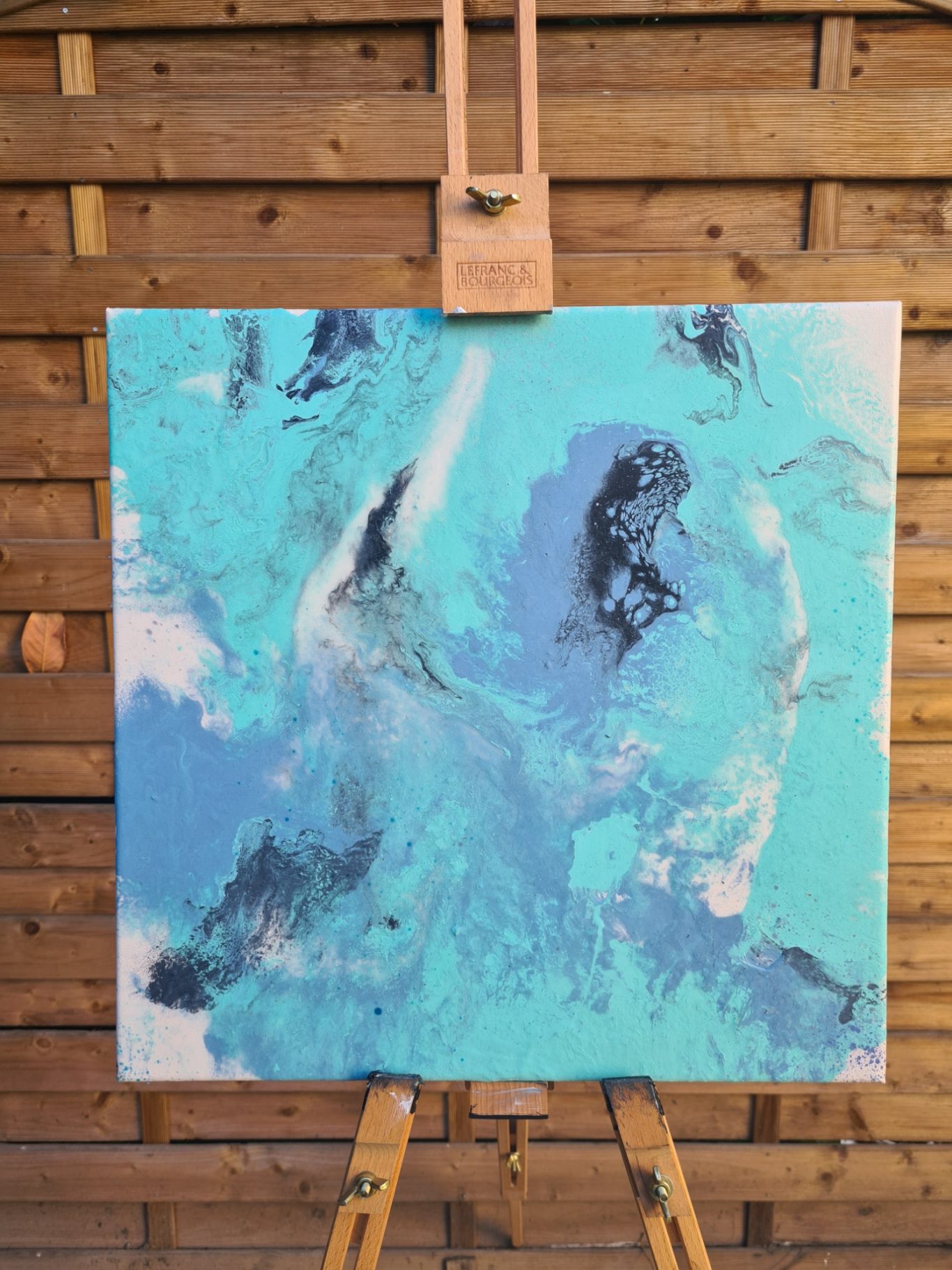 Paldives, 40 x 40 cm, 180€* Abstrakte Malerei in Blau- und Türkischtönen mit schwarzen Akzenten auf einer Staffelei.
