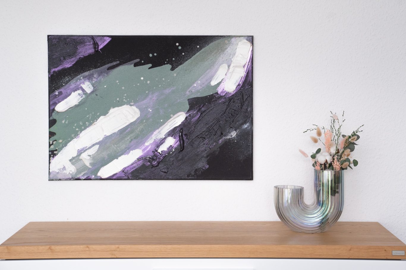 Universe, 50 x 70 cm, 600€* Abstrakte Malerei in Schwarz, Grau und Lila über einem Holztisch mit einer Vase.