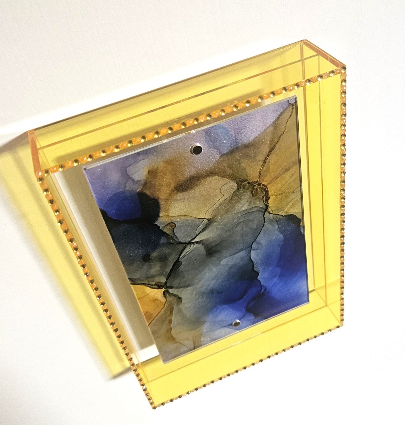 Goldchirp (nicht verfügbar) Abstrakte Malerei in Blau- und Brauntönen, eingerahmt in einem transparenten Gelb-Rahmen.