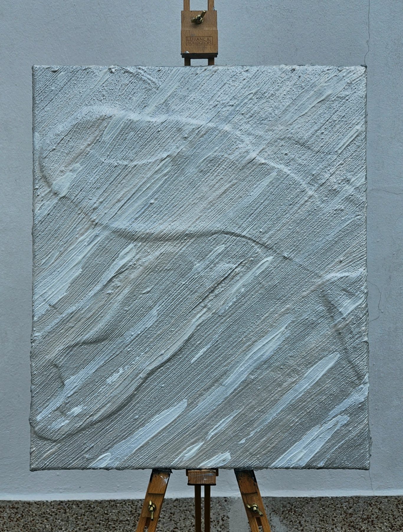 Frozen, 50 x 60 cm, 400€* Texturiertes abstraktes Kunstwerk in Weiß- und Grautönen auf einer Staffelei.