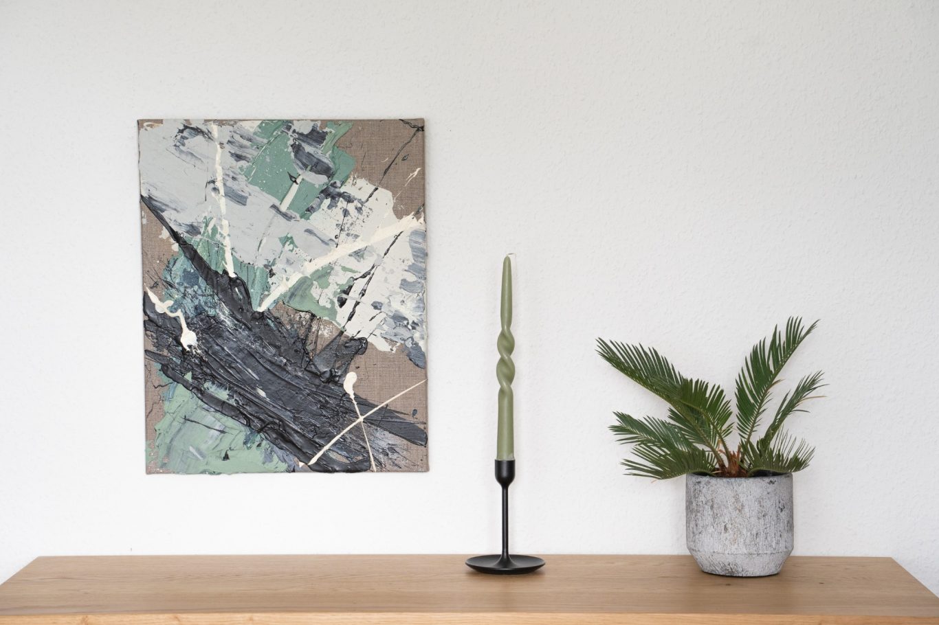 Petroleige Beige, 40 x 50 cm, 250€* Moderne Wandkunst mit grünen und braunen Farben, daneben eine Pflanze und eine Kerze.