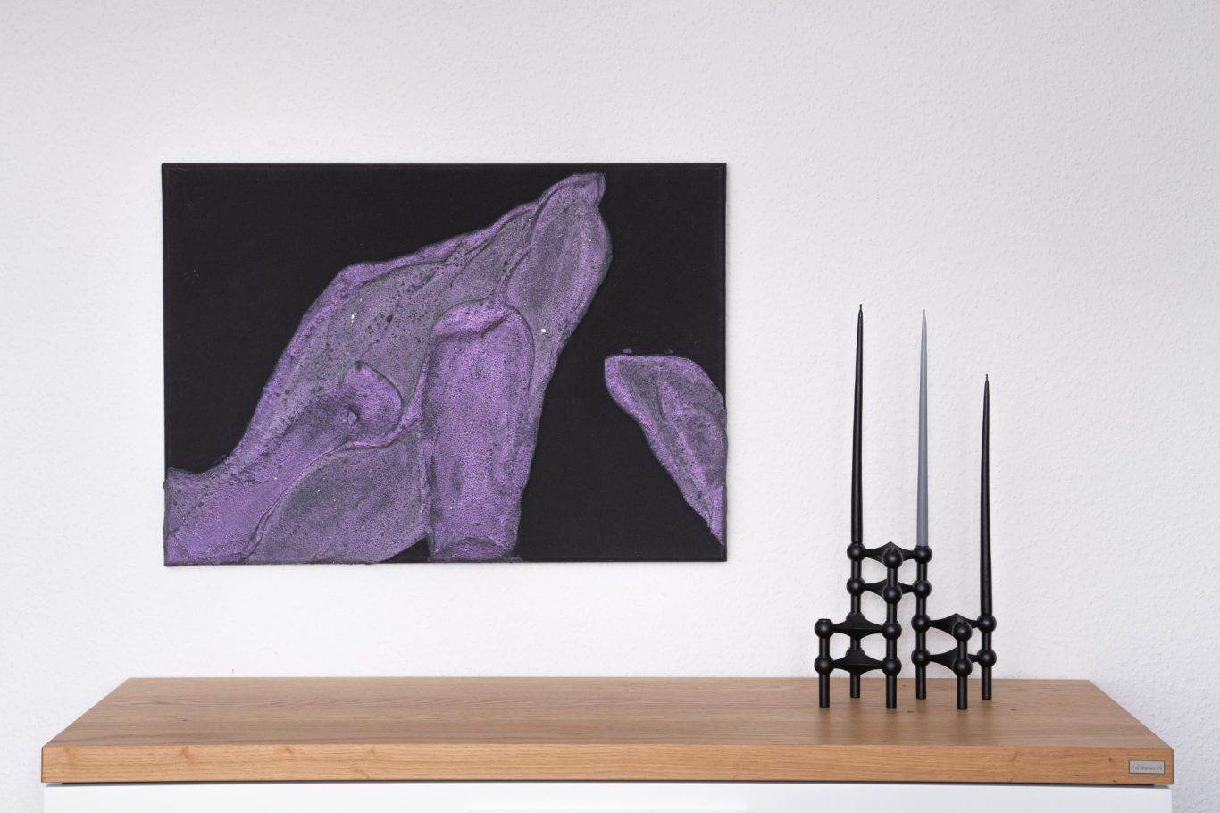 Polarlight, 50 x 70 cm, 600€* Abstrakte lila Farbakzente auf schwarzem Hintergrund, dekoriert mit schwarzen Kerzenhaltern.